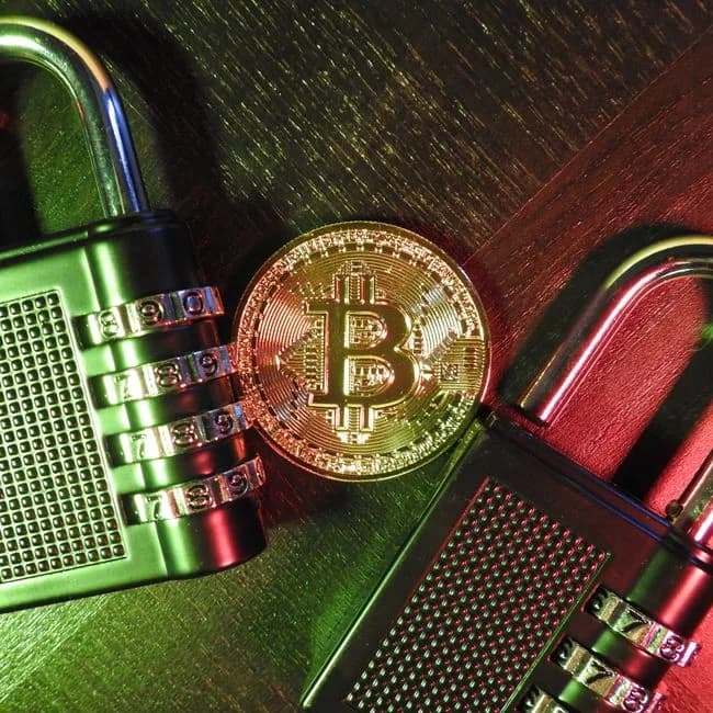 Bitcoin coin secured with combination padlocks representing how Tether freezes Iran crypto wallets under OFAC sanctions