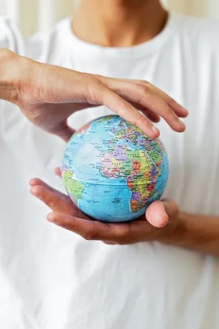Hands holding a small globe representing global sanctions enforcement on crypto
