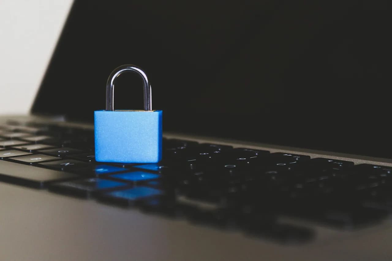 Padlock resting on a laptop keyboard representing cybersecurity and vault protection