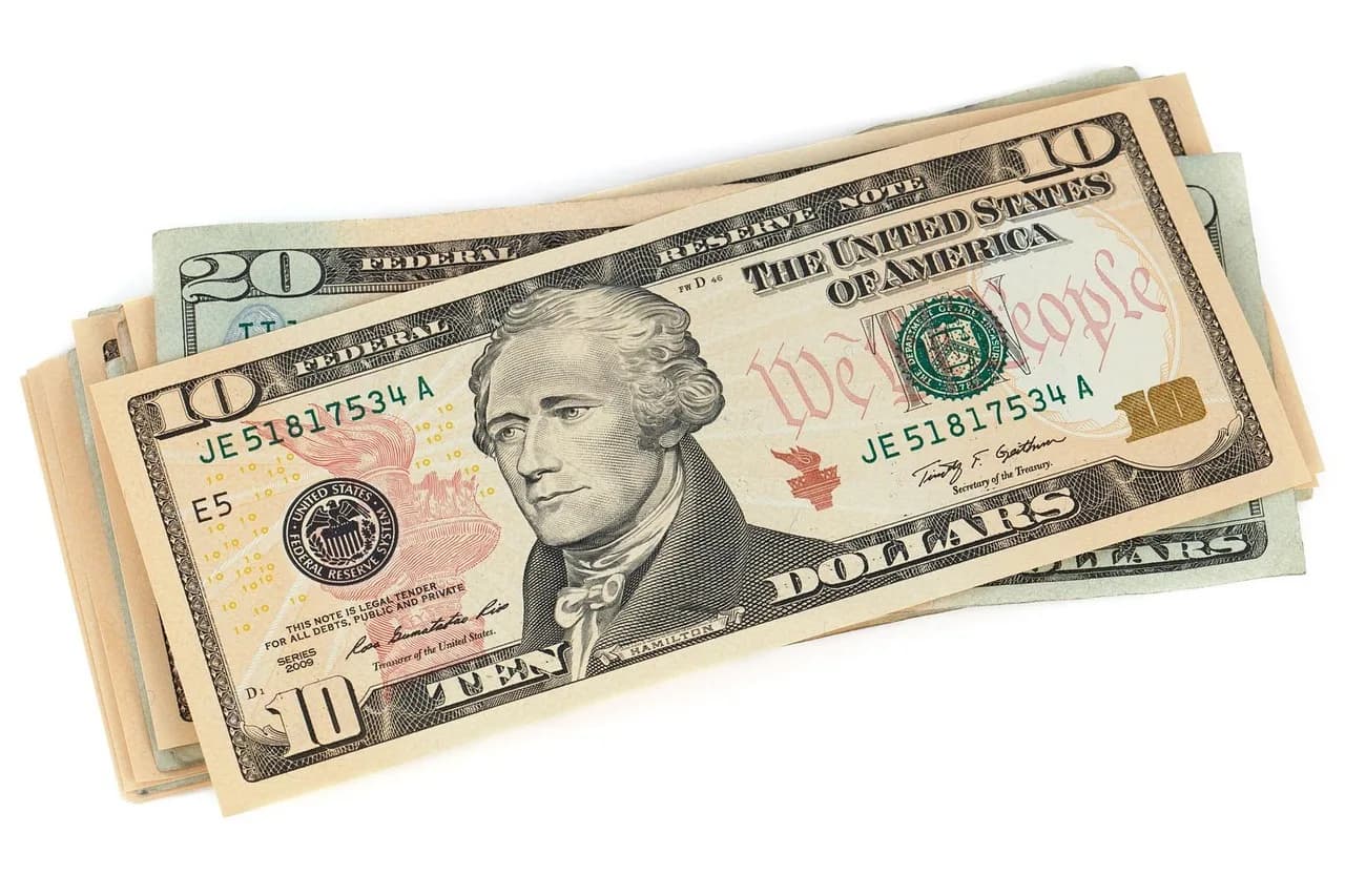 Stack of hundred dollar bills representing the scale of the Trump crypto income disclosure