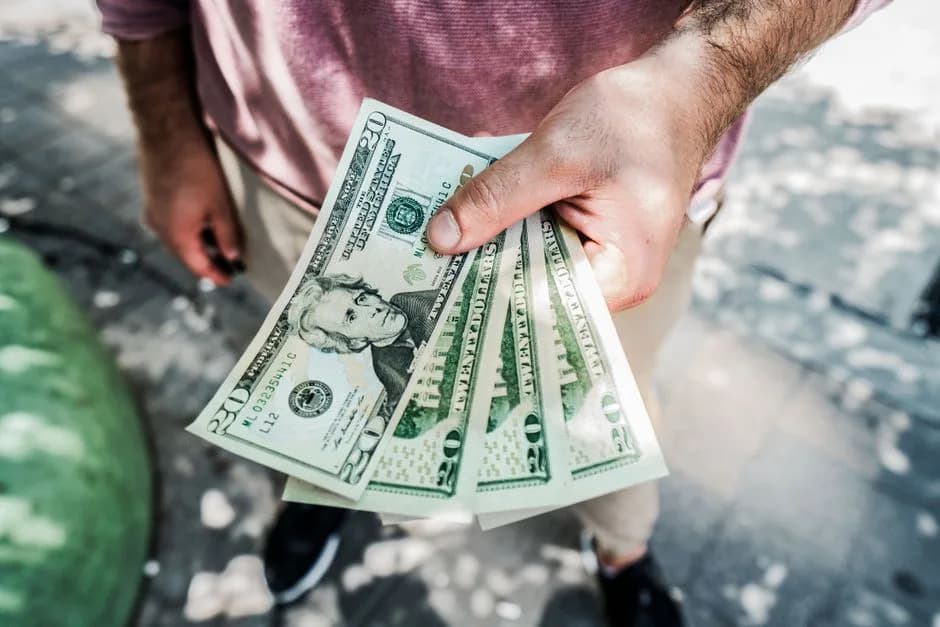 Hand holding cash bills representing paid crypto influencer promotions