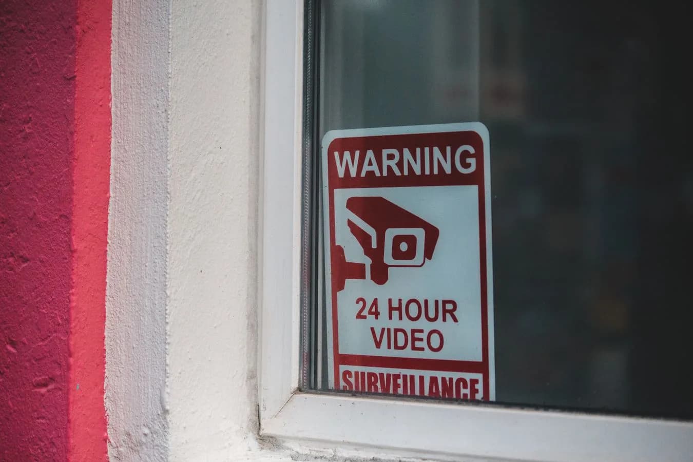 Red warning sign for video surveillance, representing red flags worth spotting before paying for an unaudited crypto tool. Photo by Erik Mclean on Pexels.